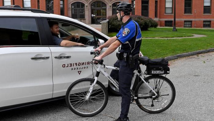 一名骑自行车的警察与一辆面包车里的一名大学员工交谈